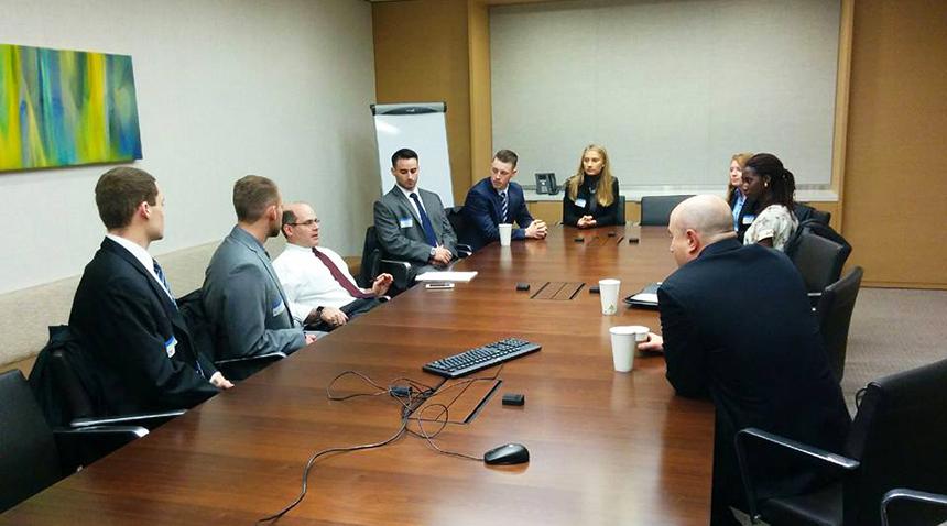 people in a meeting room talking around a large table.